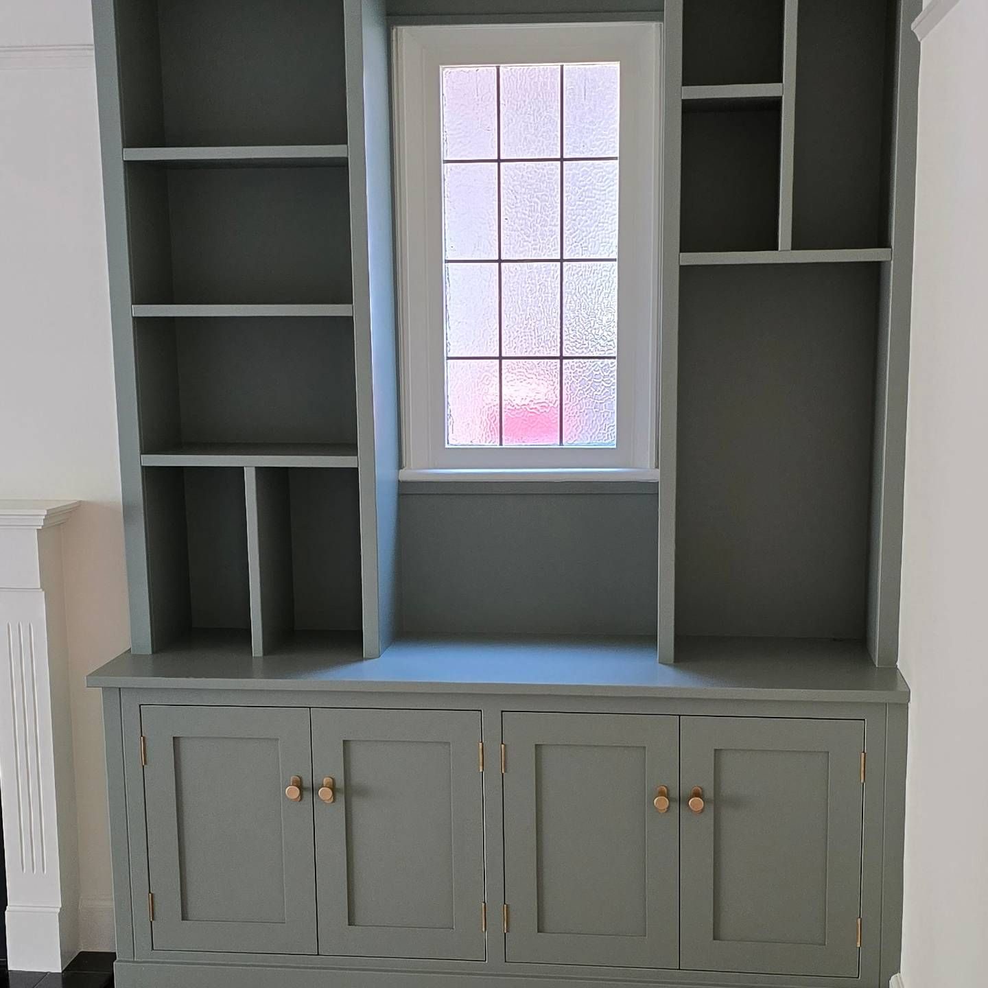 Fitted alcove shelving around a window